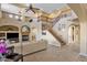 Open-concept living room with a staircase, fireplace, and large windows creating a warm and inviting space at 16401 S 29Th Ave, Phoenix, AZ 85045