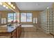 Bright main bathroom with dual vanities, large soaking tub, and glass block shower, creating a spa-like retreat at 16401 S 29Th Ave, Phoenix, AZ 85045