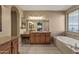 Luxurious main bathroom with dual vanities, soaking tub, glass block shower, and tiled floors at 16401 S 29Th Ave, Phoenix, AZ 85045
