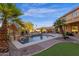 Backyard pool featuring a small water fall, palm trees, and manicured landscaping with the main house partially showing at 16401 S 29Th Ave, Phoenix, AZ 85045