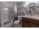Well-lit bathroom with large mirror, tub, shower, and floral wallpaper at 1654 E Jardin Pl, Casa Grande, AZ 85122