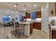 Well-lit kitchen with stainless steel appliances, a functional island with bar seating, and dark wood cabinetry at 1654 E Jardin Pl, Casa Grande, AZ 85122