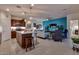 Open-concept kitchen and living area with an island, stylish furniture, and a bright accent wall at 1654 E Jardin Pl, Casa Grande, AZ 85122