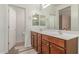 Bathroom with double vanity and large mirror reflecting the shower at 16954 W Mohave St, Goodyear, AZ 85338