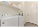 Convenient laundry room with a washer, dryer, and shelving for storage at 16954 W Mohave St, Goodyear, AZ 85338