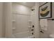 Bathroom showcasing a pristine bathtub with a shower, complemented by minimalist decor, creating a clean and serene atmosphere at 1720 W Behrend Dr, Phoenix, AZ 85027