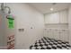 Bright laundry room with checkered flooring and white cabinets at 1720 W Behrend Dr, Phoenix, AZ 85027