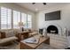 Charming living room with a brick fireplace, plantation shutters, modern decor, and plenty of natural light at 1720 W Behrend Dr, Phoenix, AZ 85027