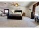 A well-lit primary bedroom features neutral decor, a ceiling fan, and carpeted flooring at 1758 E San Xavier Dr, Casa Grande, AZ 85122