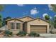 Charming single-story home with a two-car garage, desert landscaping, and a neutral color palette under a clear blue sky at 18161 W Cielo Grande Ave, Surprise, AZ 85387