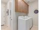 Efficient laundry room with overhead cabinets and modern washing machine and dryer at 18161 W Cielo Grande Ave, Surprise, AZ 85387