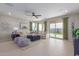 Spacious living room with neutral walls, tile flooring, a ceiling fan, and a sliding glass door to the backyard at 18161 W Cielo Grande Ave, Surprise, AZ 85387