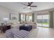 Bright living room with stylish seating, modern decor, a ceiling fan, and a view of the backyard at 18161 W Cielo Grande Ave, Surprise, AZ 85387