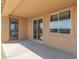 Covered outdoor patio space with neutral colors, concrete floor, glass door, and window overlooking the backyard at 18161 W Cielo Grande Ave, Surprise, AZ 85387