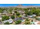 Scenic aerial view of residential area, featuring mature landscaping, solar panels, pools, and mountain views at 1839 E Palo Verde Dr, Phoenix, AZ 85016