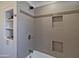 Bathroom shower with gray tiling, decorative trim, and recessed shelving at 1839 E Palo Verde Dr, Phoenix, AZ 85016