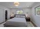 Bedroom features a queen-sized bed, modern lighting, and a view from the window at 1839 E Palo Verde Dr, Phoenix, AZ 85016