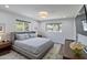Bright bedroom with a plush queen-sized bed, stylish decor, and plenty of natural light from the two windows at 1839 E Palo Verde Dr, Phoenix, AZ 85016