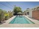Stunning outdoor pool with in-pool seating, landscaping, and privacy fencing at 1839 E Palo Verde Dr, Phoenix, AZ 85016