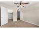 This bedroom features a carpeted floor, ceiling fan, and doorways leading to a closet and hallway at 1887 E La Donna Dr, Tempe, AZ 85283