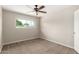 This carpeted bedroom features a ceiling fan and window with a view of the neighborhood at 1887 E La Donna Dr, Tempe, AZ 85283