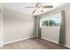 This carpeted bedroom features a ceiling fan and a window with curtains and a view of a palm tree at 1887 E La Donna Dr, Tempe, AZ 85283