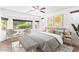 This relaxing bedroom has many windows allowing natural light, a ceiling fan and neutral paint and carpet at 19319 E Thornton Rd, Queen Creek, AZ 85142
