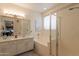Bathroom featuring double sinks, marble countertops, a soaking tub, and a glass shower at 19347 E Thornton Rd, Queen Creek, AZ 85142