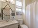 Bathroom features a single sink, mirror, and a toilet with a window and shower with curtain at 19347 E Thornton Rd, Queen Creek, AZ 85142