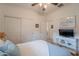 Bright bedroom with a ceiling fan, carpet, closet, beach-themed decorations and a mounted television at 19347 E Thornton Rd, Queen Creek, AZ 85142
