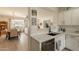 Modern kitchen with white cabinets, backsplash, stainless appliances, and an adjacent living area at 19347 E Thornton Rd, Queen Creek, AZ 85142