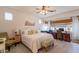 Spacious main bedroom with a ceiling fan, large window, and a built-in desk with decorative touches at 19347 E Thornton Rd, Queen Creek, AZ 85142