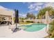 Inviting backyard pool with umbrella, ample seating, and lush green landscaping at 19347 E Thornton Rd, Queen Creek, AZ 85142