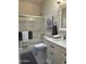 Bright bathroom featuring a shower-over-tub setup with glass door and a granite vanity at 2013 E Valencia Dr, Phoenix, AZ 85042