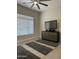 Bedroom with ceiling fan, ample natural light, and modern dresser with mounted TV at 2013 E Valencia Dr, Phoenix, AZ 85042