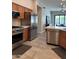 Well-equipped kitchen with stainless steel appliances, wood cabinets, and tile backsplash at 2013 E Valencia Dr, Phoenix, AZ 85042