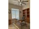 Well lit office with a glass table, office chair, and built in shelves at 2013 E Valencia Dr, Phoenix, AZ 85042