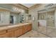 A bathroom featuring double sinks, a shower with sliding glass doors, and travertine tile flooring at 209 N 237Th Ave, Buckeye, AZ 85396