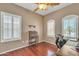 This bedroom features hardwood floors, shuttered windows allowing lots of natural light, and space for a home office at 209 N 237Th Ave, Buckeye, AZ 85396
