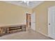 An unfurnished bedroom with beige walls and carpet and an adjacent bathroom and closet at 209 N 237Th Ave, Buckeye, AZ 85396