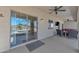 Relaxing covered patio features a ceiling fan, comfortable seating, and sliding glass doors leading to the pool at 209 N 237Th Ave, Buckeye, AZ 85396