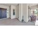 Covered porch with neutral tones, space for seating, and a secure front entrance at 209 N 237Th Ave, Buckeye, AZ 85396