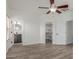 Open bedroom showing wood-look flooring, ceiling fan, ensuite bathroom, and walk-in closet at 2326 E Spruce Dr, Chandler, AZ 85286