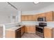 Well-lit kitchen with wood cabinets, stainless steel appliances, and a breakfast bar at 2326 E Spruce Dr, Chandler, AZ 85286
