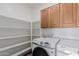Spacious laundry room with built-in shelving, cabinets, and modern washer and dryer at 2326 E Spruce Dr, Chandler, AZ 85286