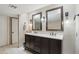 Spacious bathroom with a double sink vanity, decorative mirrors, and neutral tiling at 3030 N Hayden Rd # 28, Scottsdale, AZ 85251