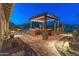Resort-style backyard featuring an outdoor kitchen, dining area, pool, and desert landscape at 31705 N 128Th Dr, Peoria, AZ 85383