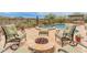 Relaxing backyard featuring a cozy fire pit with seating and natural desert landscape offers a serene atmosphere at 31705 N 128Th Dr, Peoria, AZ 85383