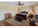 Primary bedroom featuring a tufted leather bed, ceiling fan and traditional style bedside tables and cabinets at 31705 N 128Th Dr, Peoria, AZ 85383