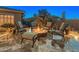 Inviting backyard with a stone fire pit surrounded by comfortable seating, perfect for cozy outdoor gatherings at 31705 N 128Th Dr, Peoria, AZ 85383